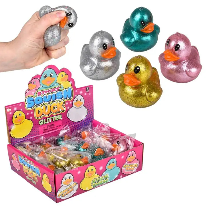 Display box of 2.25 inch glitter squish duck stress toys in assorted metallic colors including silver, teal, gold, and pink
