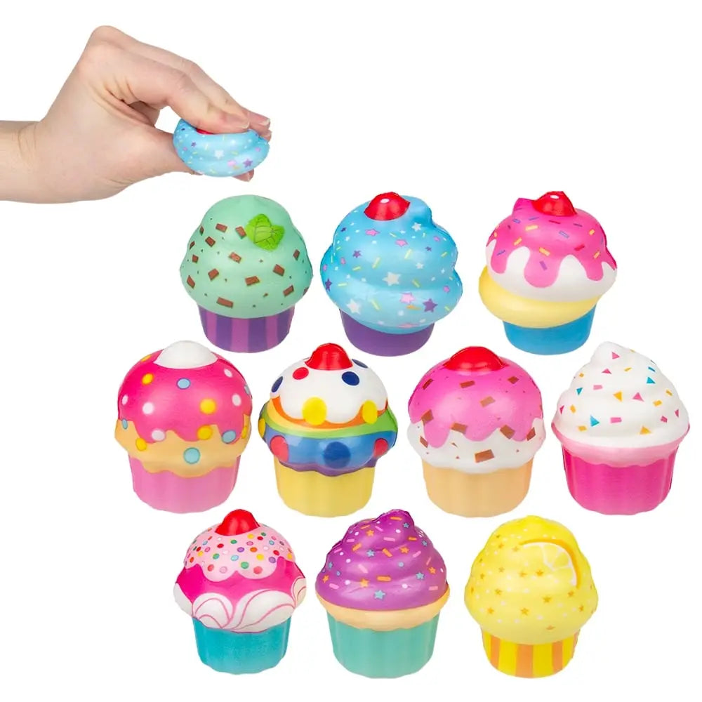 Assorted colorful 2 inch cupcake squish stress toys with frosting, sprinkles, and bright cupcake designs on a light background