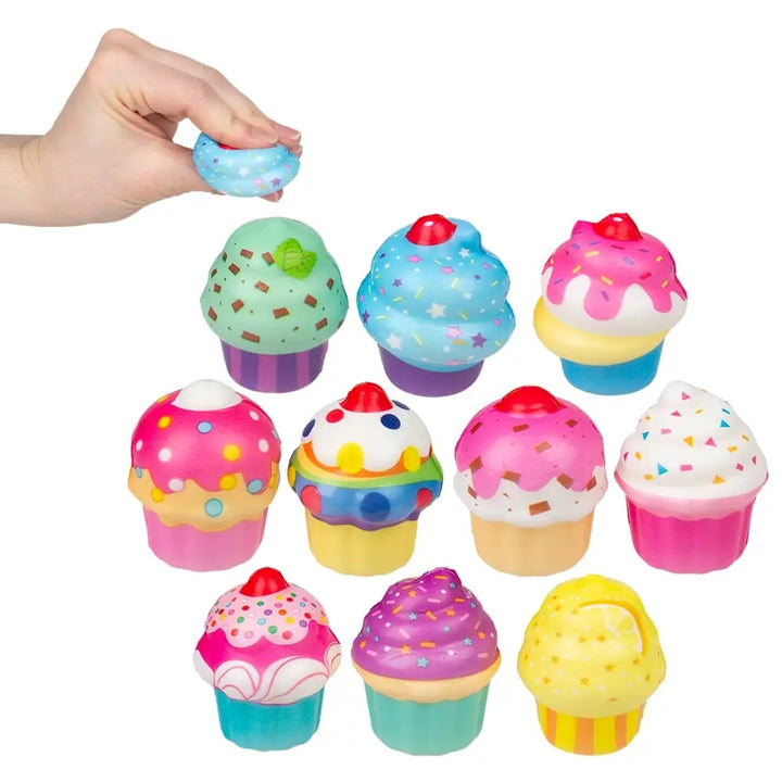 Assorted colorful 2 inch cupcake squish stress toys with frosting, sprinkles, and bright cupcake designs on a light background