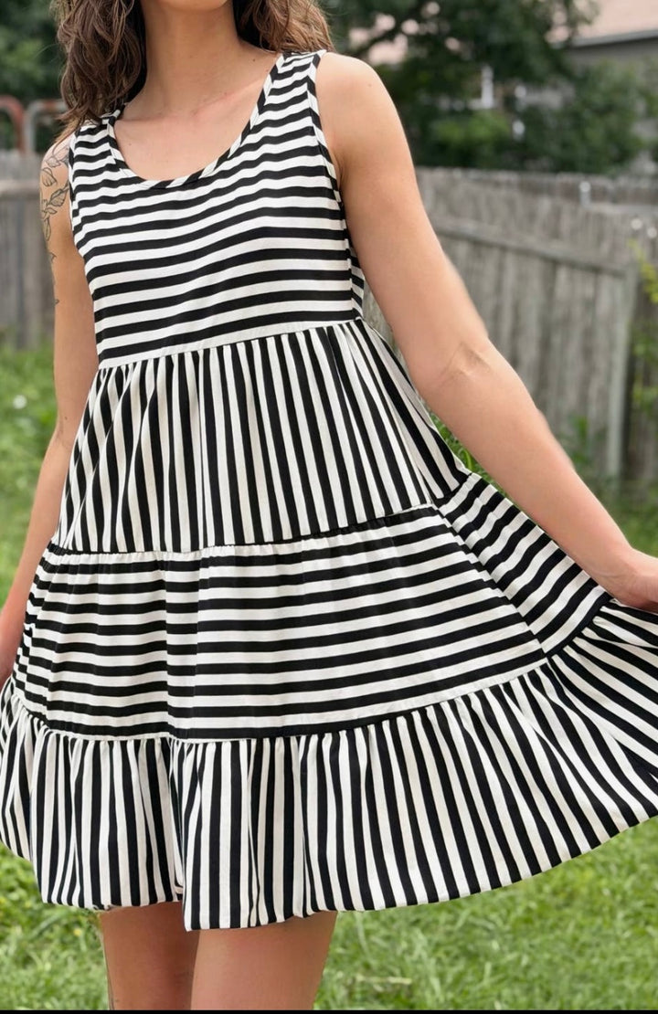 Person wearing a black and white striped dress outdoors.