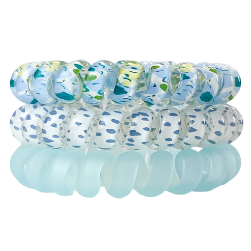 Set of blue and white patterned hair ties on a white background