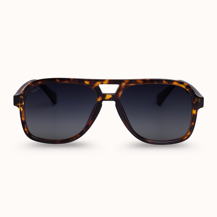 Sunglasses with tortoiseshell frame and dark lenses on a white background