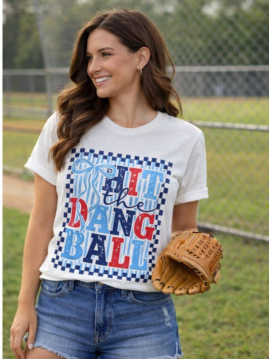 Woman wearing Hit the Dang Ball graphic tee at baseball field holding glove
