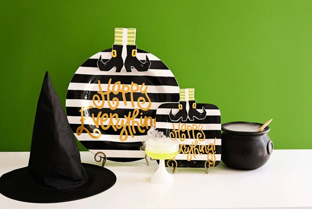 Halloween-themed table decor set including a black witch hat, striped platter with gold &