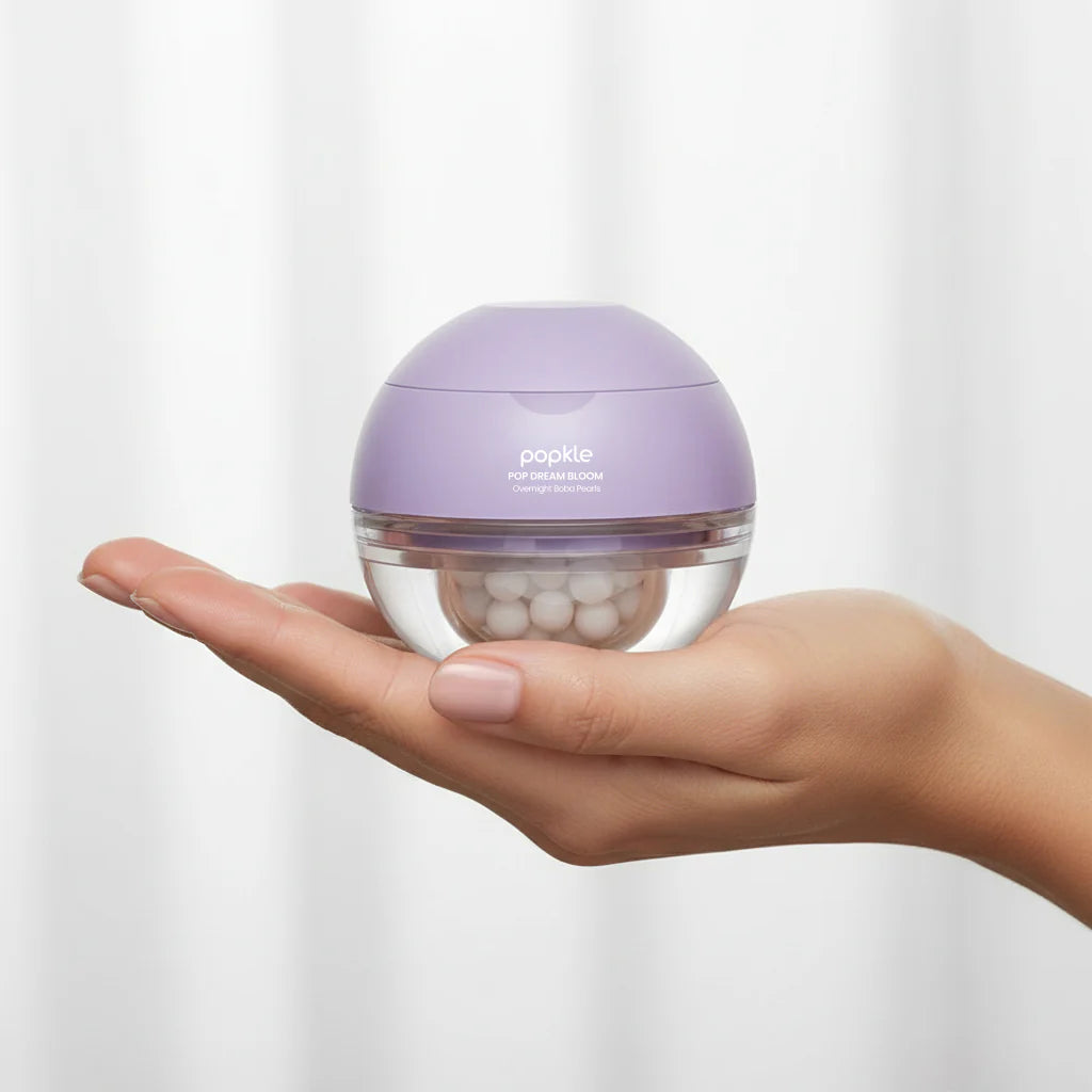 Hand holding a small purple container with white beads on a light gray background