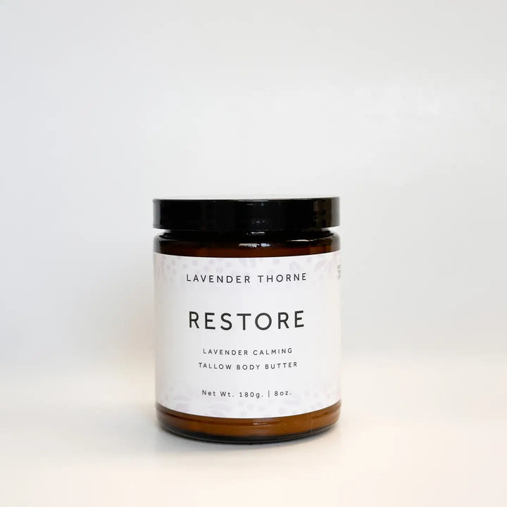 Lavender Thorne Restore Tallow Body Butter in an amber glass jar featuring a deeply moisturizing formula made with grass-fed beef tallow and calming lavender essential oil.