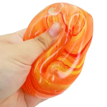 Orange marbled cube putty filled squishy toy being squeezed in a hand to show soft texture