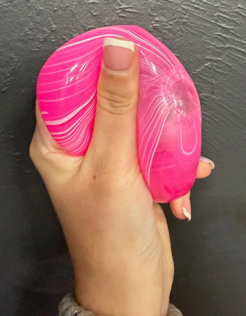 Hand holding a pink  Viral cube squishy