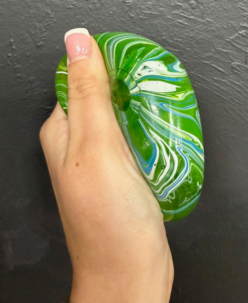 Hand holding a green Viral cube squishy