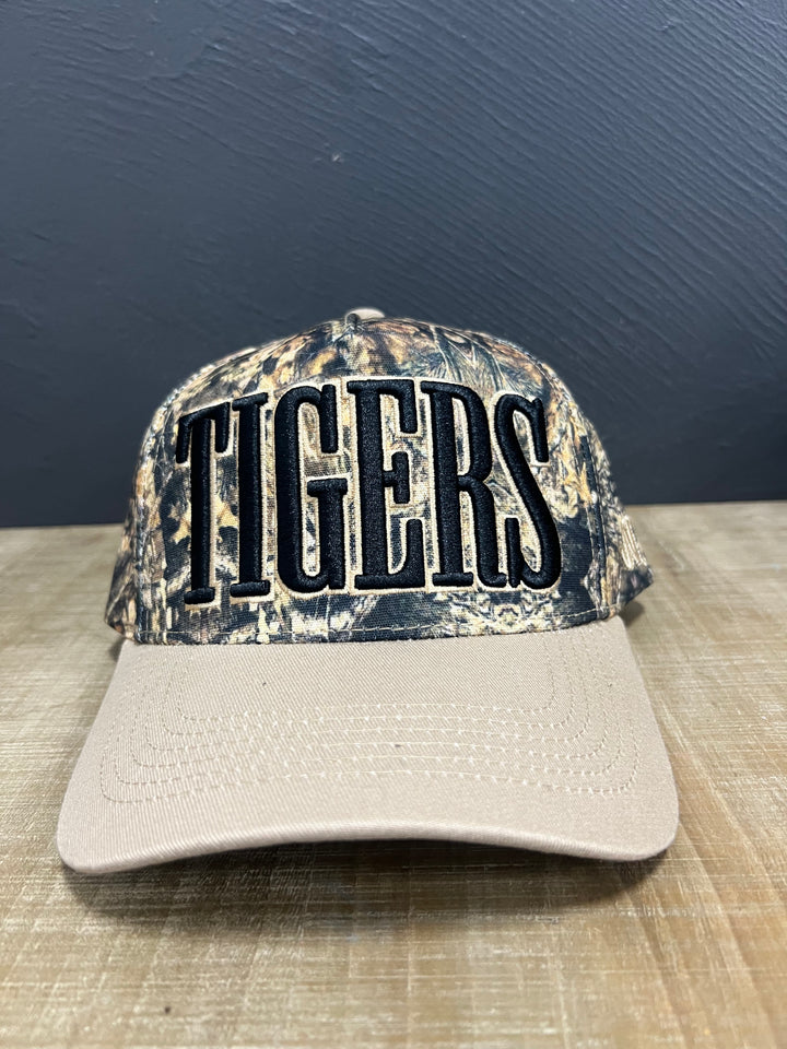Camo Tigers mascot hat with raised black lettering, light brown outline, and light brown brim.