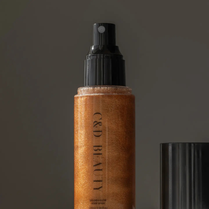 C&amp;D Beauty Golden Glow Body Spray featuring a shimmering golden formula in a sleek spray bottle designed to provide radiant, hydrated skin with a tropical pineapple and coconut fragrance.