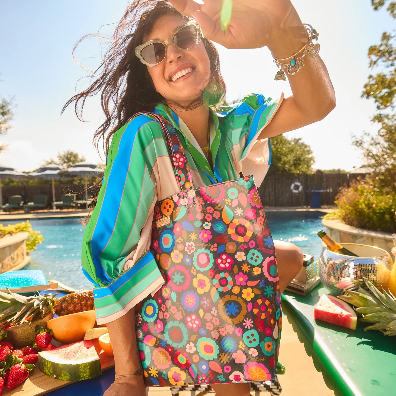 Consuela Amelie floral grab and go bag styled by pool with summer outfit