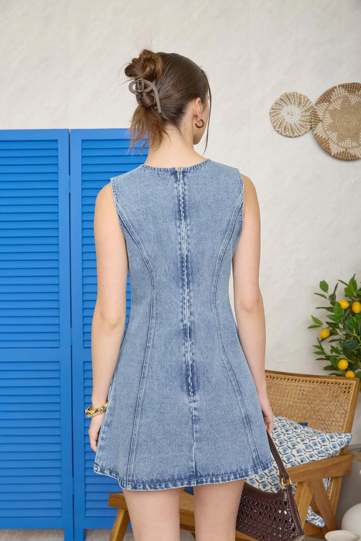 Back view of sleeveless denim mini dress with seam detail and A-line silhouette