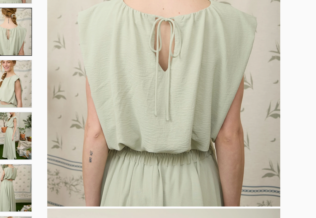 Back view of dusty mint two piece skirt set showing tie detail on sleeveless top