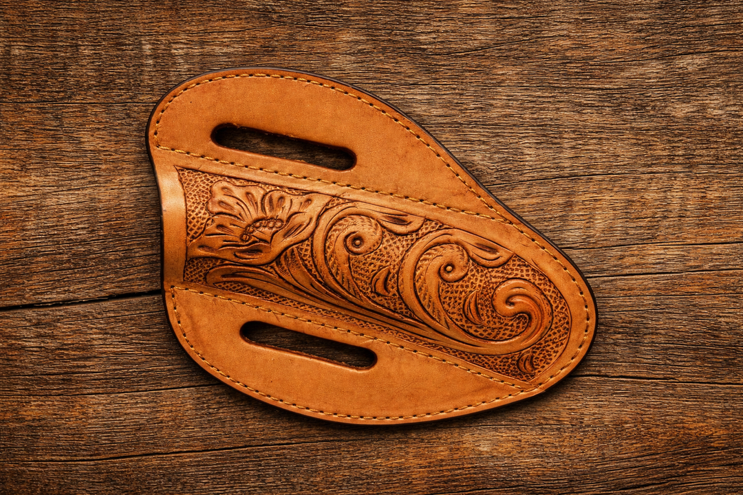 Hand tooled leather knife sheath with floral western design on rustic wood background lay flat