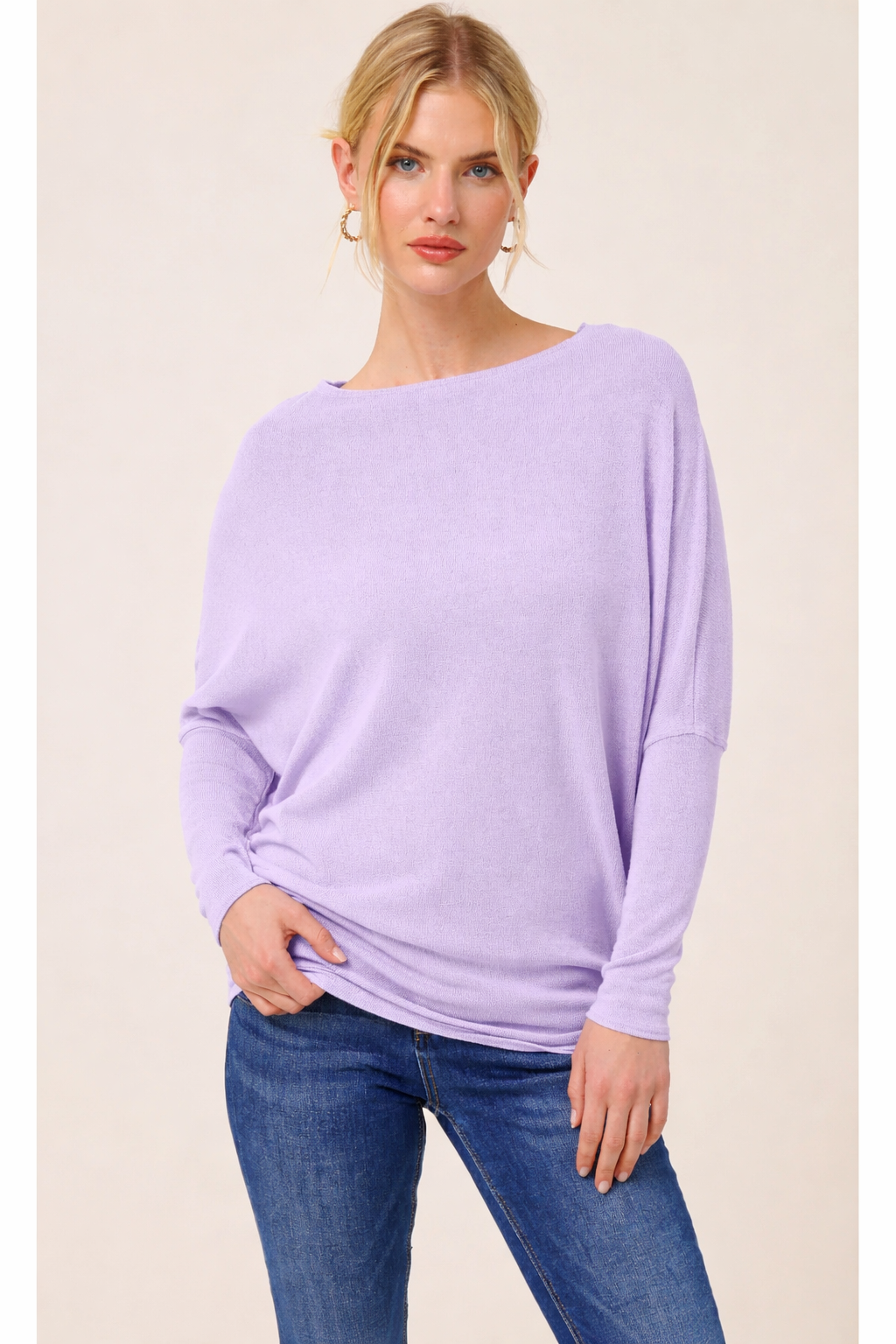 Woman wearing lavender dolman sleeve top styled with jeans