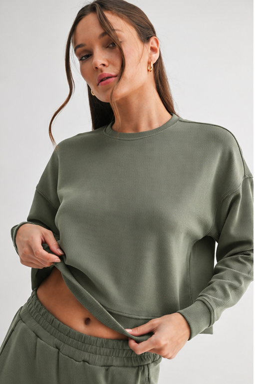 Woman wearing a green sweatshirt against a white background