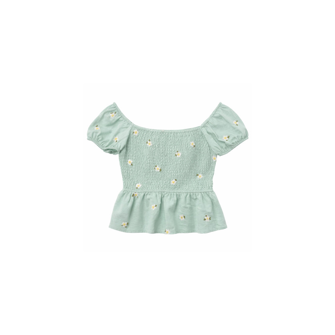 Mint green smocked off-shoulder top with white daisy embroidery and peplum hem on white background.
