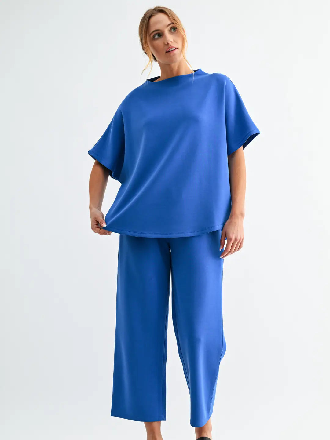 Model wearing the Mono B Laguna Casual Comfort Set with relaxed short sleeve top and cropped wide-leg pants in bright blue modal blend fabric.