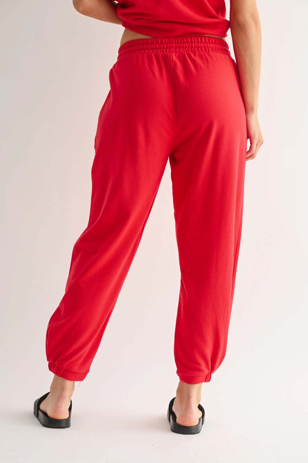 Back view of red Mono B joggers with elastic waistband and tapered leg