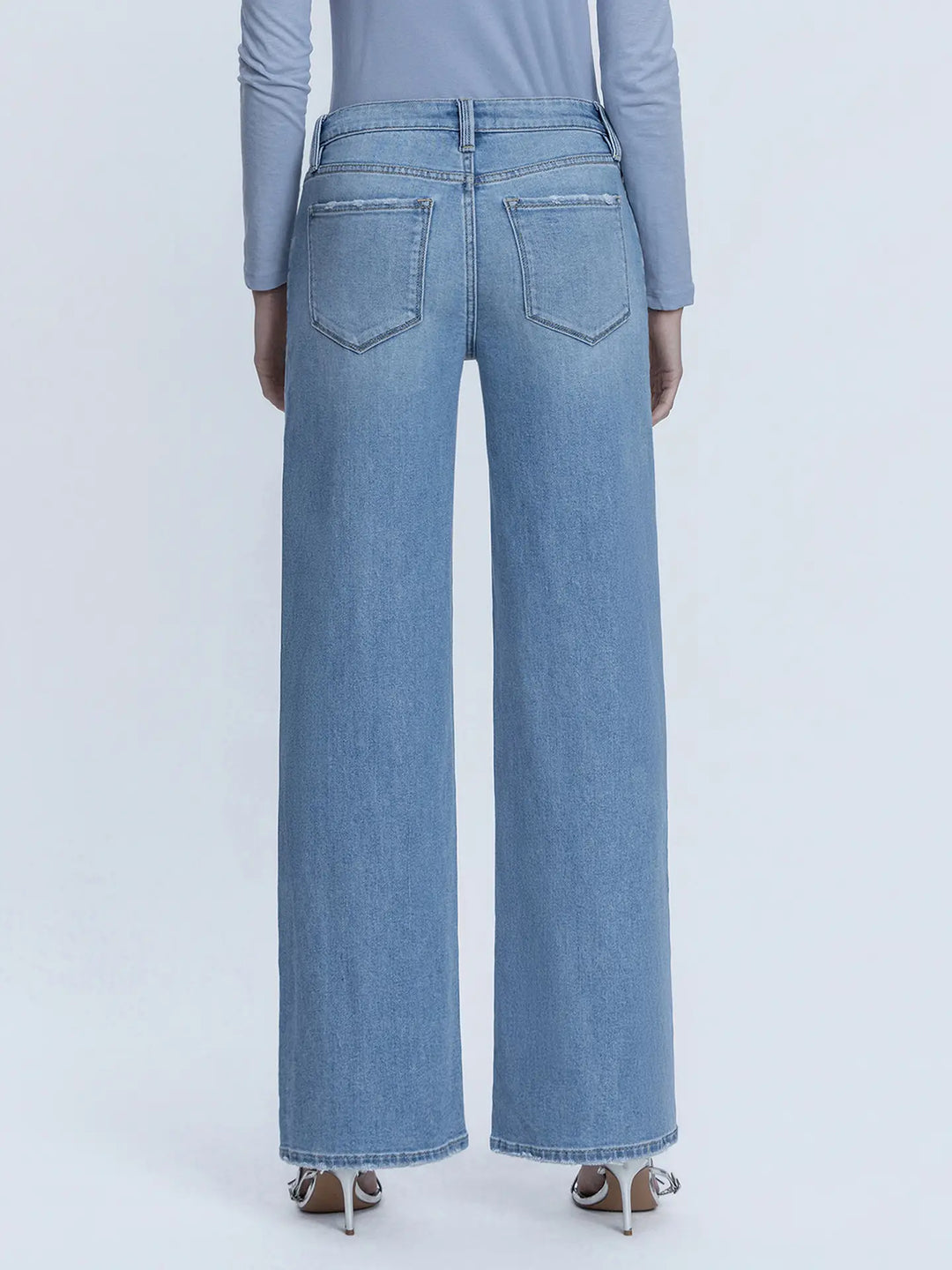 Light blue jeans worn by a person on a white background